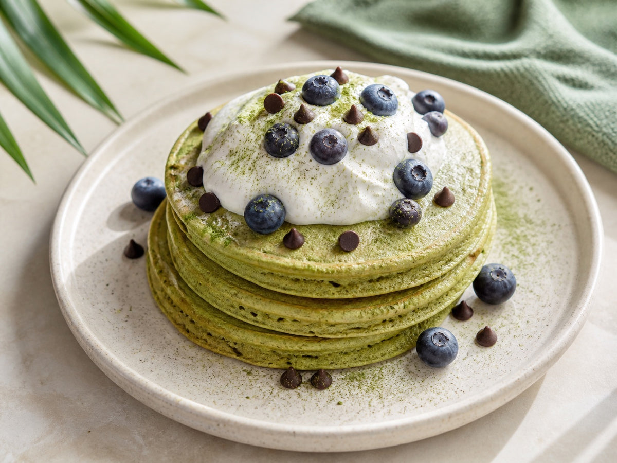 Matcha mochi pancakes with coconut cream and blueberries.